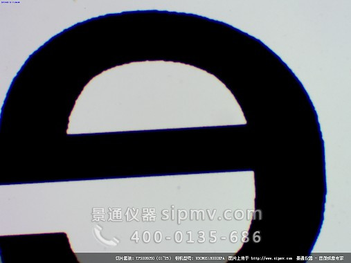 顯微鏡下的字母 e ( 字母邊緣顏色是由物鏡的色差引起的)